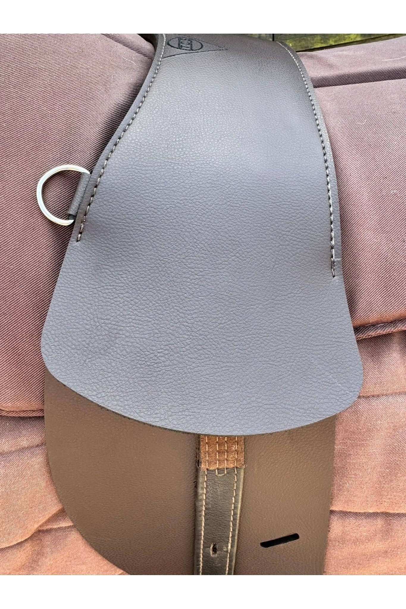 A synthetic chocolate brown Total Contact Saddle close up on a brown saddle pad and a brown half pad