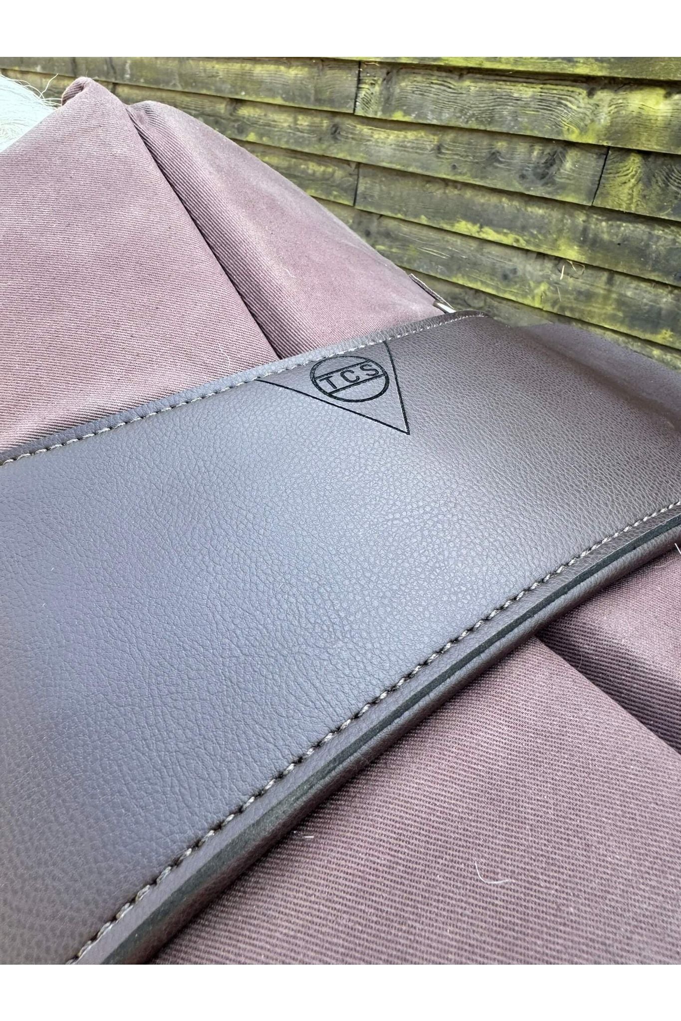 A synthetic chocolate brown Total Contact Saddle close up on a brown saddle pad