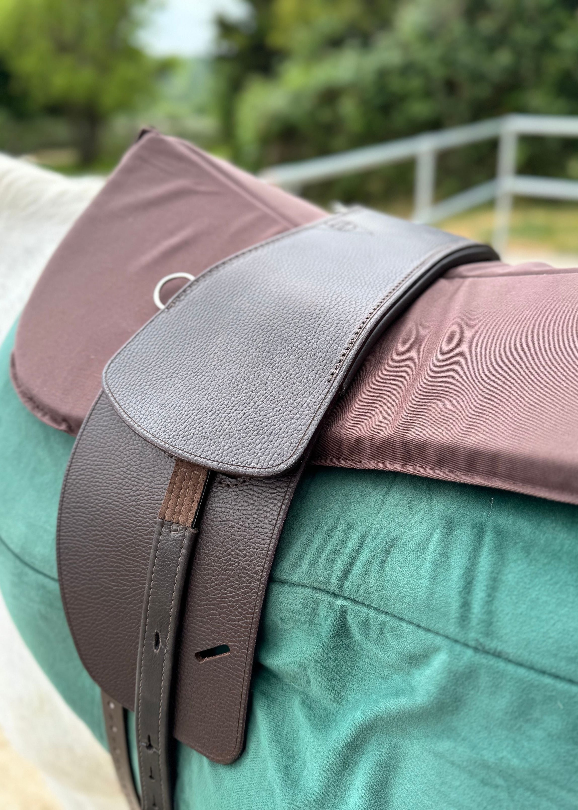 A Classic TCS saddle in our Havana brown finish with the TCS Webbers in brown on a green saddle pad and brown half pad