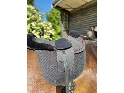 A Premium black TCS saddle on a dark bay horse with black TCS Webbers on a black saddle pad and black half pad