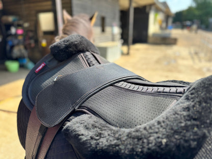 A Premium black TCS saddle seen from the top on a dark bay horse with black TCS Webbers on a black saddle pad and black half pad