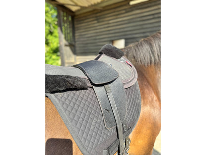 A Premium black TCS saddle on a dark bay horse with black TCS Webbers on a black saddle pad and black half pad
