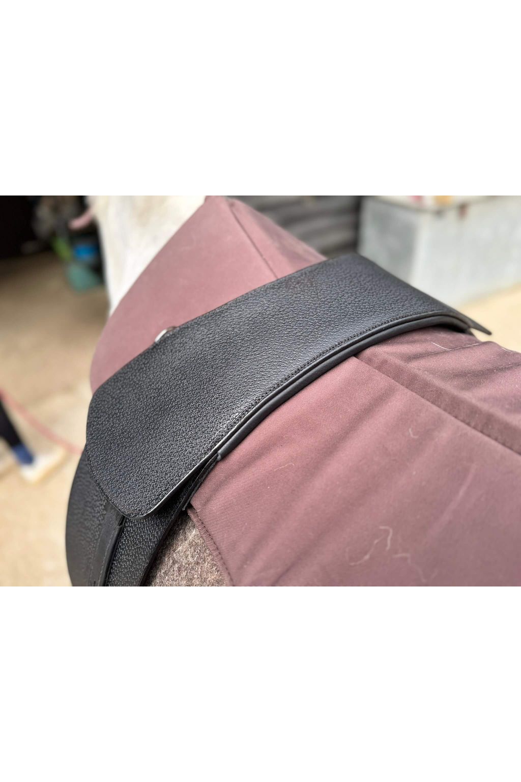 A premium black total contact treeless saddle on a grey horse wearing a felt saddle pad and a brown half pad